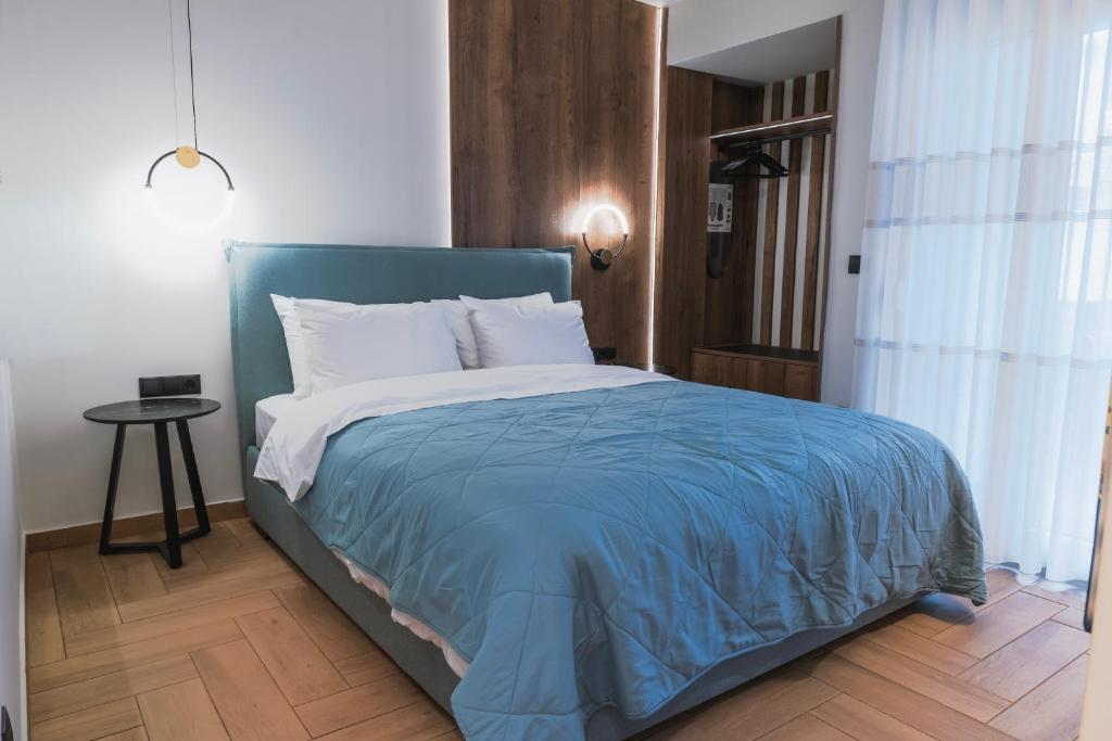 a bedroom with a large bed with a blue blanket at Lighthouse Nest AXD in Alexandroupoli