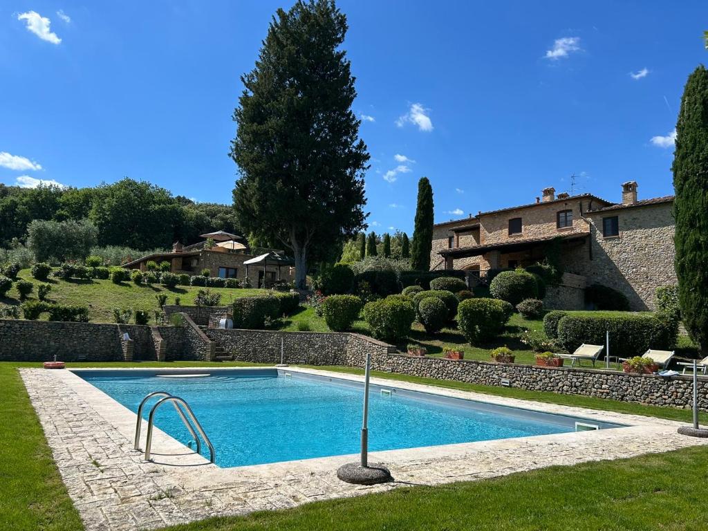 a swimming pool in a yard with a house at Podere Casanuova in San Gimignano
