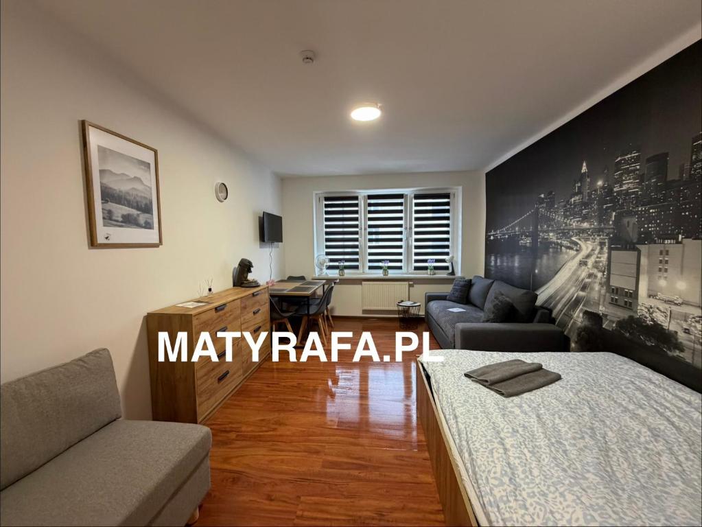 a living room with a bed and a desk at ApartmentsByMatyrafa-XVI in Tarnowskie Góry