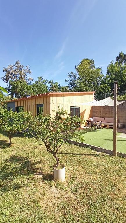 a house with a tree in a yard at A Cabaña do Cumiar in Ponteareas