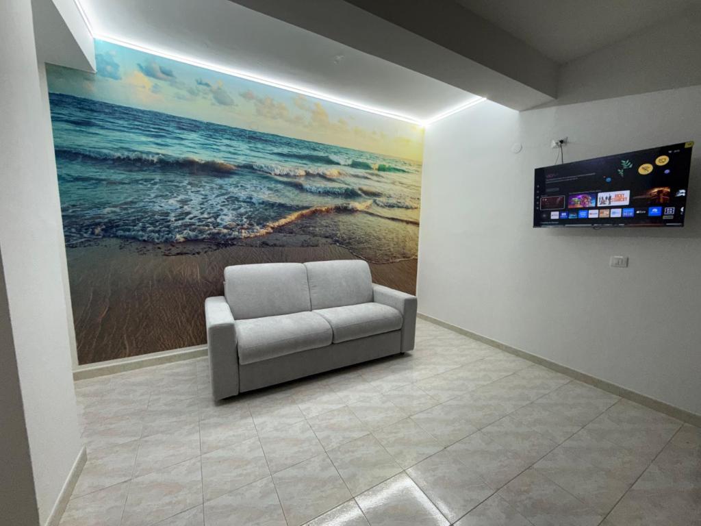 a couch in a room with a painting on the wall at SeaMood Casa Vacanze in Praia a Mare