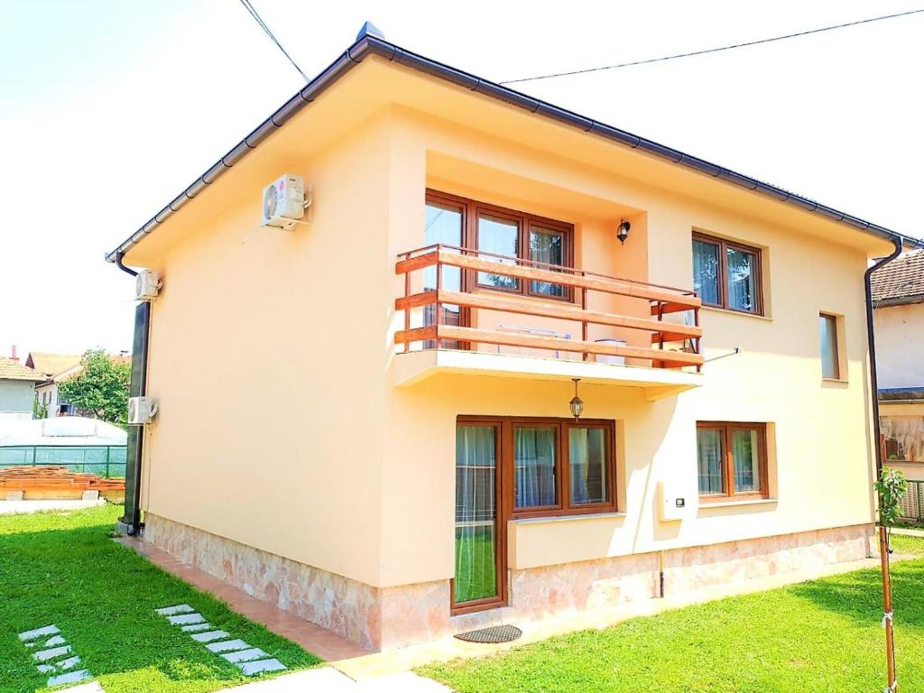 a house with a balcony on top of it at Ilidza Holiday Home in Sarajevo