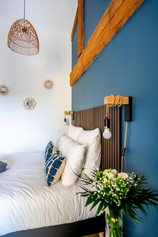 a bedroom with blue walls and a bed with white pillows at Vina Rhona - Loft de charme entre Rhône et Vignes climatisé in Condrieu