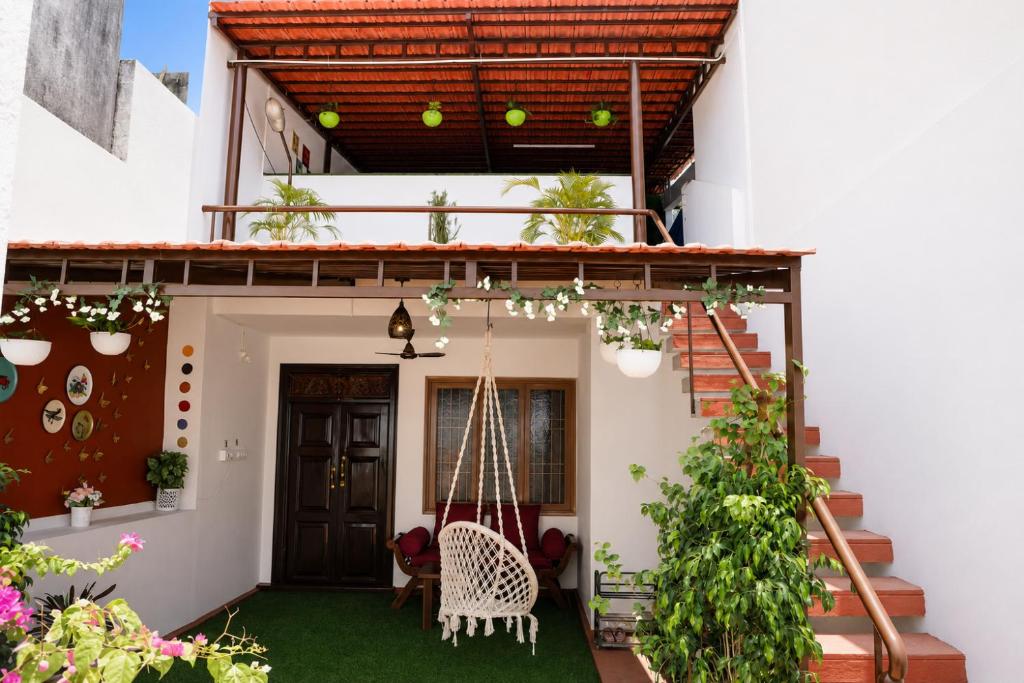 a house with a porch with a swing at Villa LOR in Pondicherry