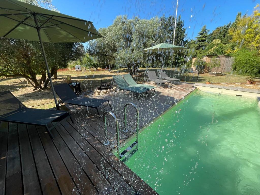 a swimming pool with two chairs and an umbrella at Batisse de vacance cadre exceptionnel in Fréjus