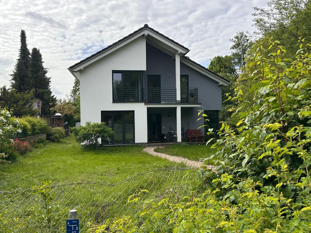 a white house with a fence in the yard at Dom przy Panke in Kolonie Röntgental