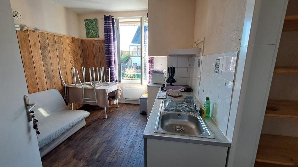 a small kitchen with a sink and a couch at Les Centaurées in Égletons
