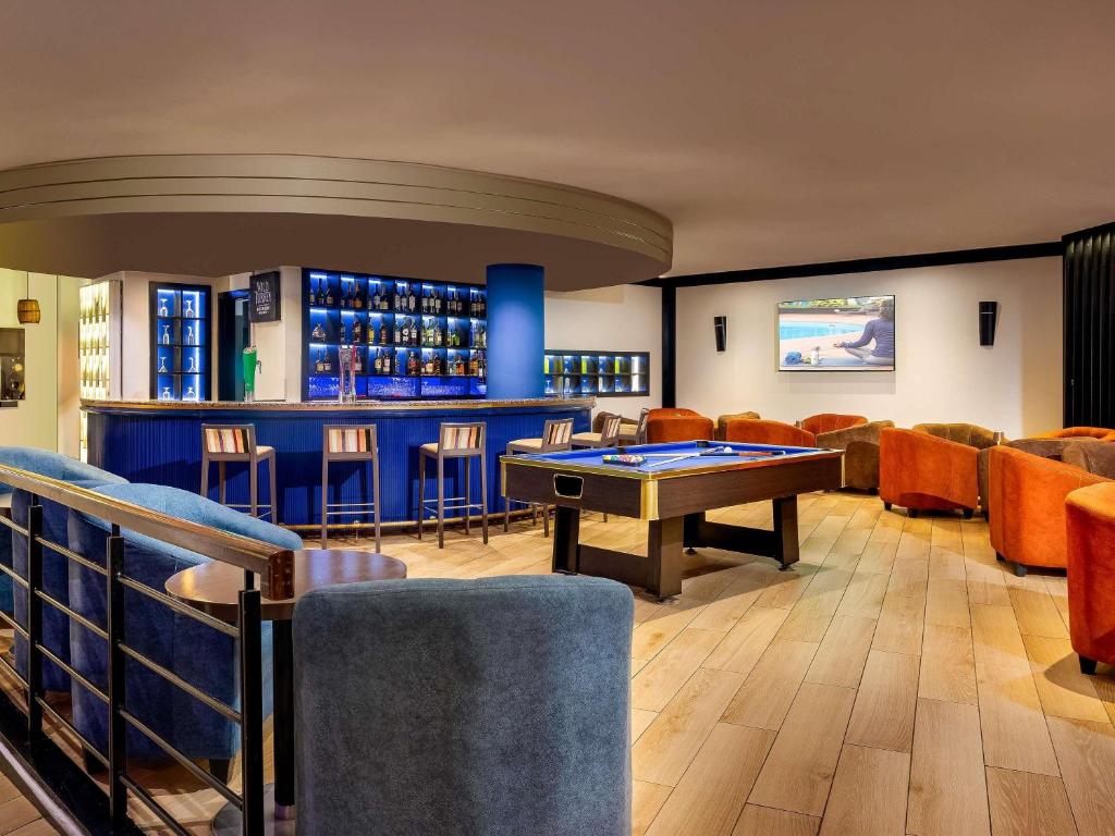 a bar with a ping pong table in a room at Novotel Port Harcourt in Port Harcourt