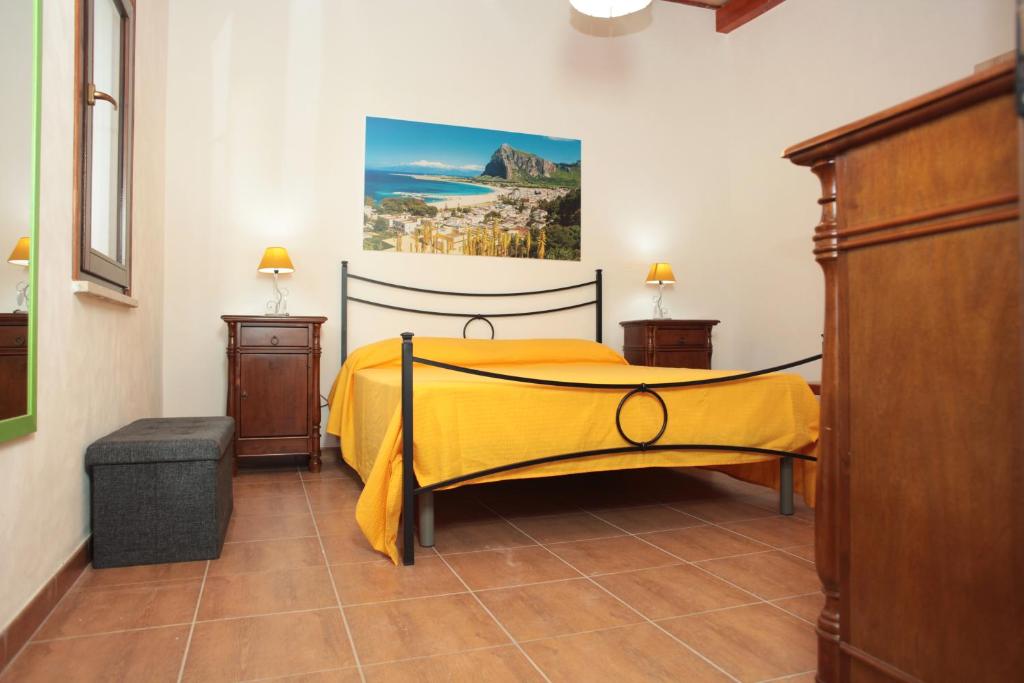 ein Schlafzimmer mit einem Bett mit gelber Tagesdecke in der Unterkunft Residence Lion in San Vito lo Capo