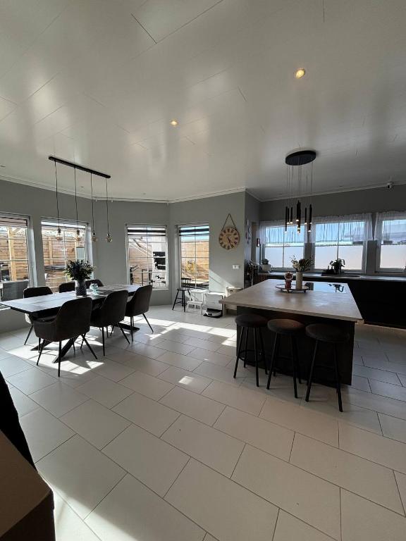 a large kitchen and dining room with tables and chairs at BergÁs in Njarðvík