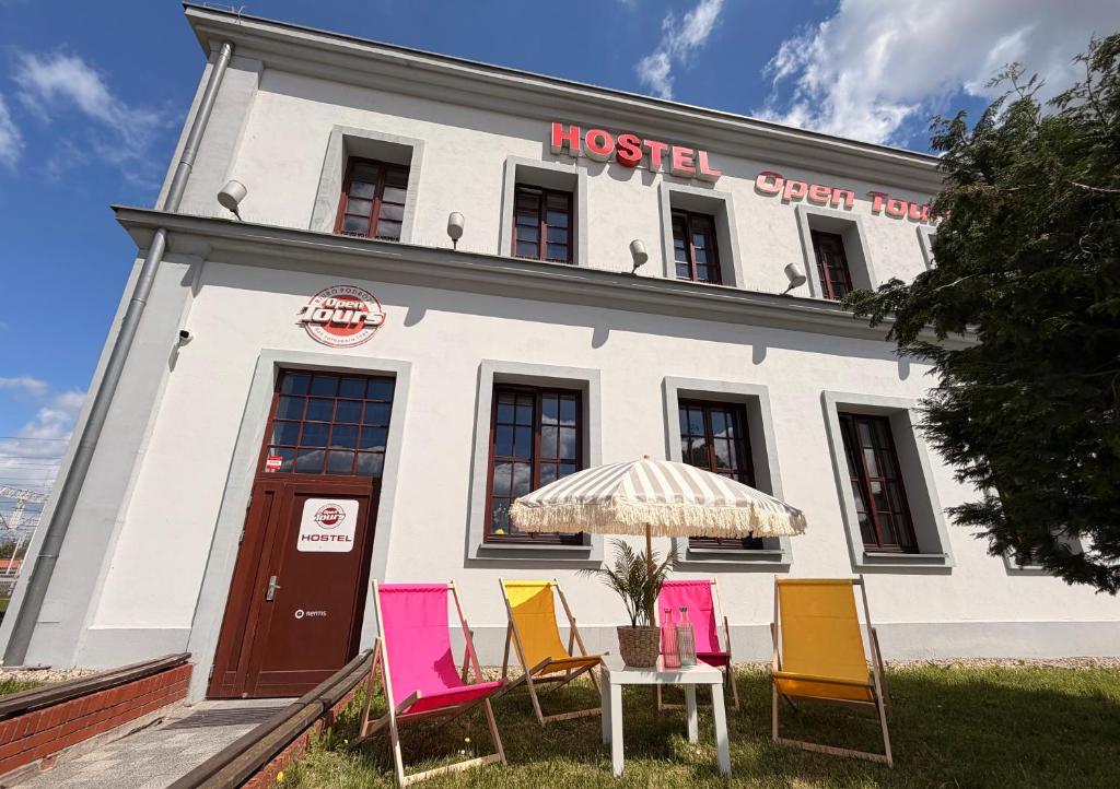 a group of chairs and an umbrella in front of a building at Open Tours in Ełk