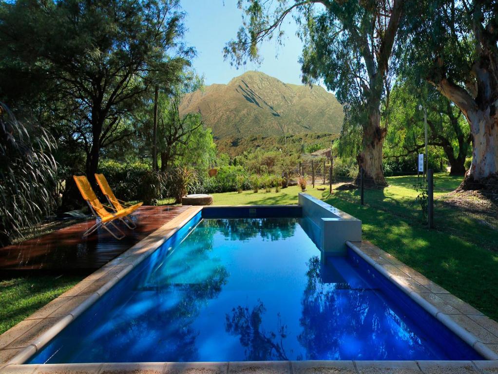 a swimming pool in a yard with mountains in the background at Cabañas Estancia Balumba in Capilla del Monte