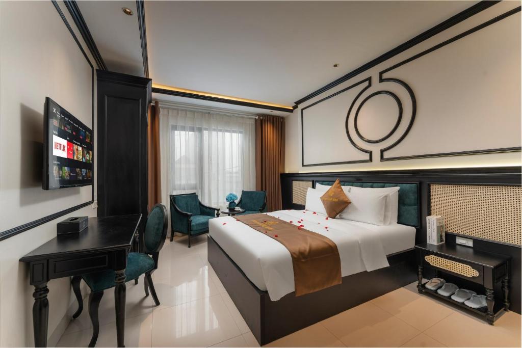 a hotel room with a bed and a desk and a television at Grand Luxury Hotel Bắc Ninh in Chu Mẫu