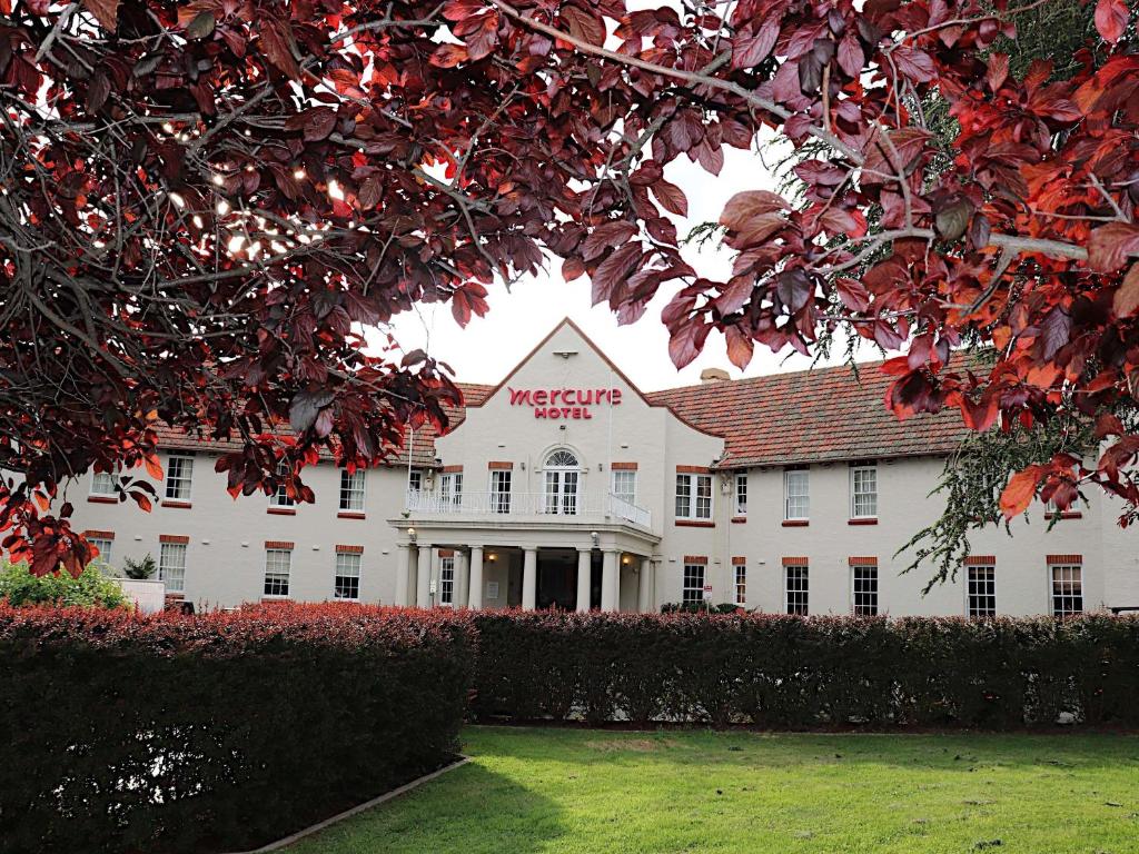 a large white building with a sign on it at Mercure Canberra in Canberra