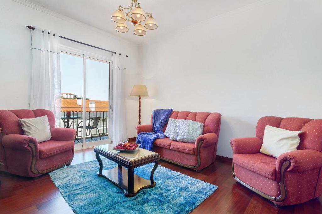 a living room with two chairs and a table at Paradise Dream in Caniço