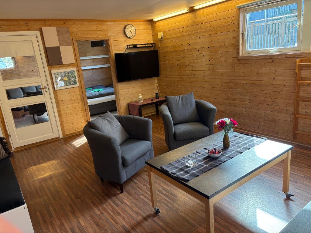 a living room with two chairs and a table at Child friendly basement apartment in Stavanger