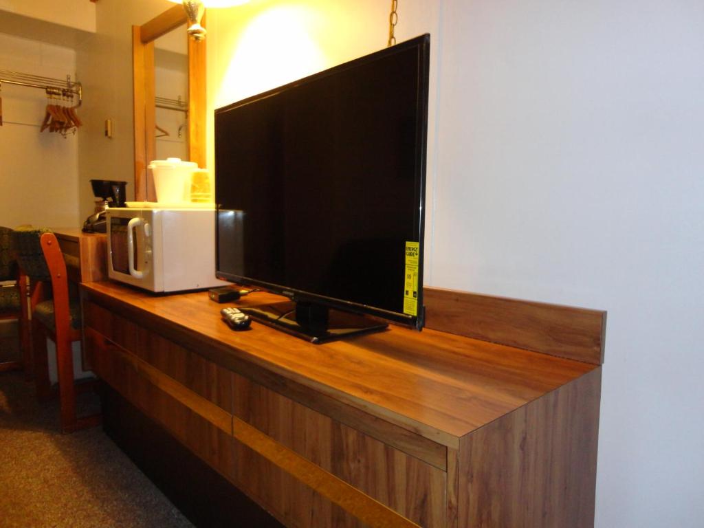a flat screen tv sitting on top of a wooden cabinet at Tomahawk Motor Lodge in Riverton