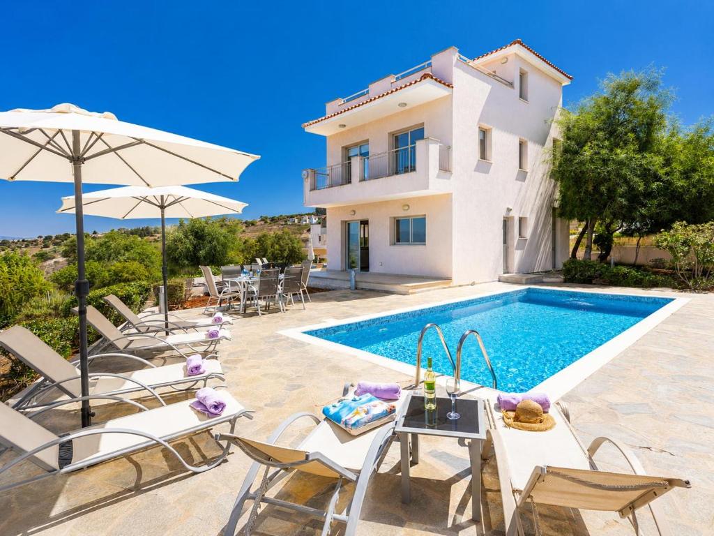 a villa with a swimming pool and a house at Villa Panorama Tessera in Drousha