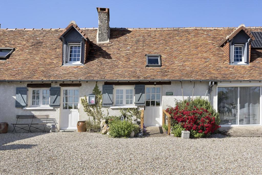 a white house with windows and a roof at La Ferme Des Bigornes in Châtillon-sur-Indre