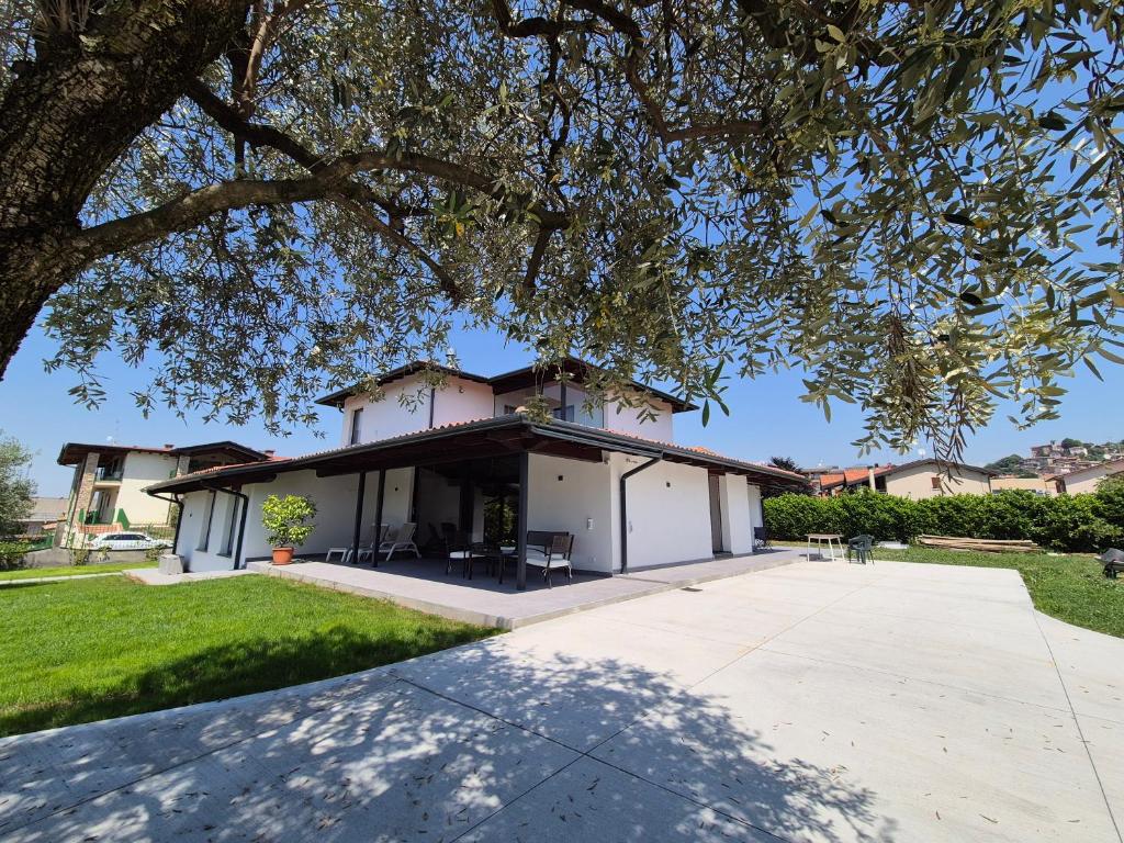 a house with a tree in front of a driveway at FRANCIACORTA LAKELAND Lodge in Capriolo