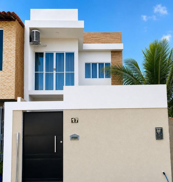 a white house with a black garage at Casa paraíso dos milagres in São Miguel dos Milagres