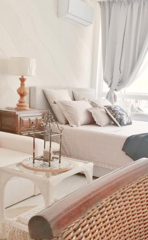 a white bedroom with a bed and a table with a candle at Luxury Studio with Balcony in Sunny Beach
