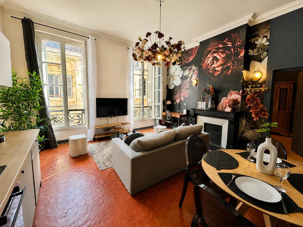 a living room with a couch and a table and a television at Le Boudoir des Capucins - T2 Plein Centre Ville proche Canebière Vieux Port - Gare TGV Saint Charles in Marseille
