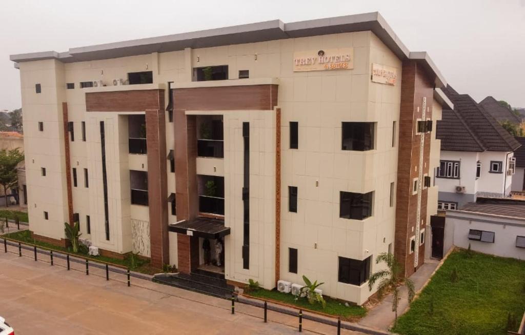 a large white building with a sign on it at Trev Hotels and Suites in Asaba