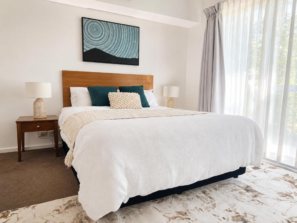 a bedroom with a large bed and a window at Cozy water side apartment - Jetty in Mandurah