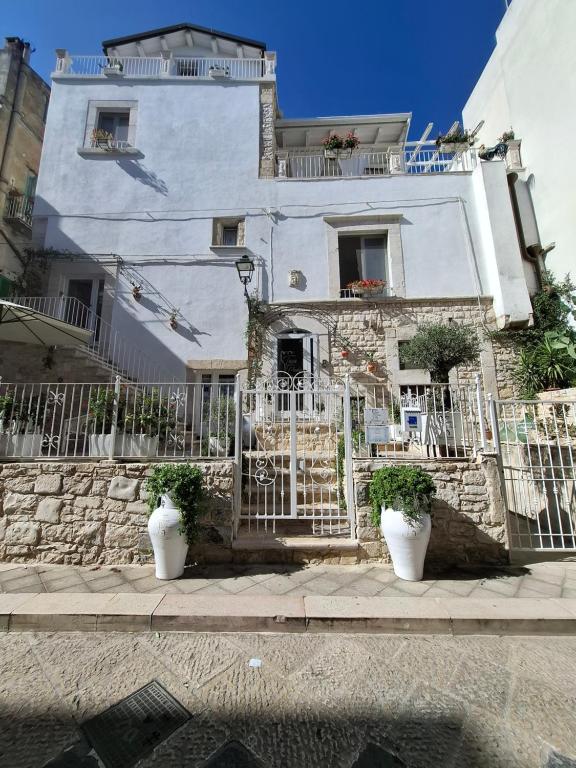 a white house with two potted plants in front of it at Torre Pendio b&b in Corato