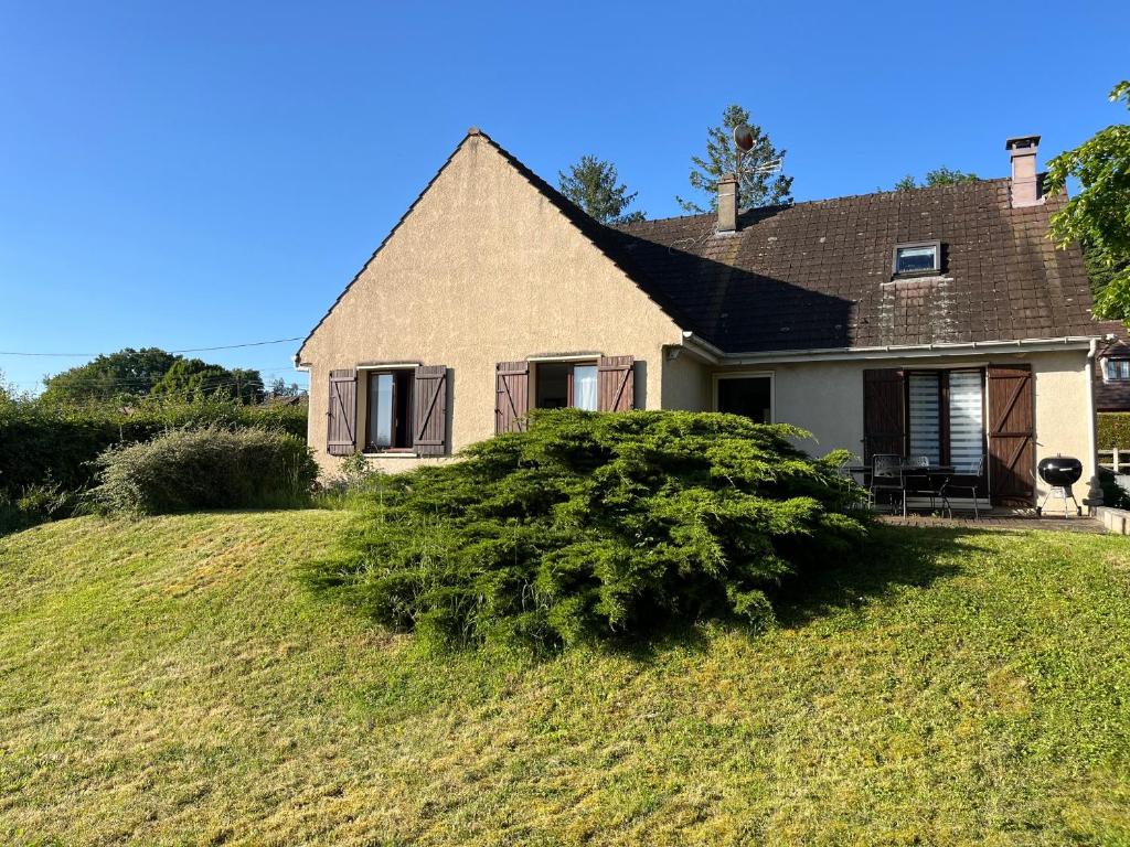 a house on a hill with a bush in front of it at Maison Vexin in Boury-en-Vexin