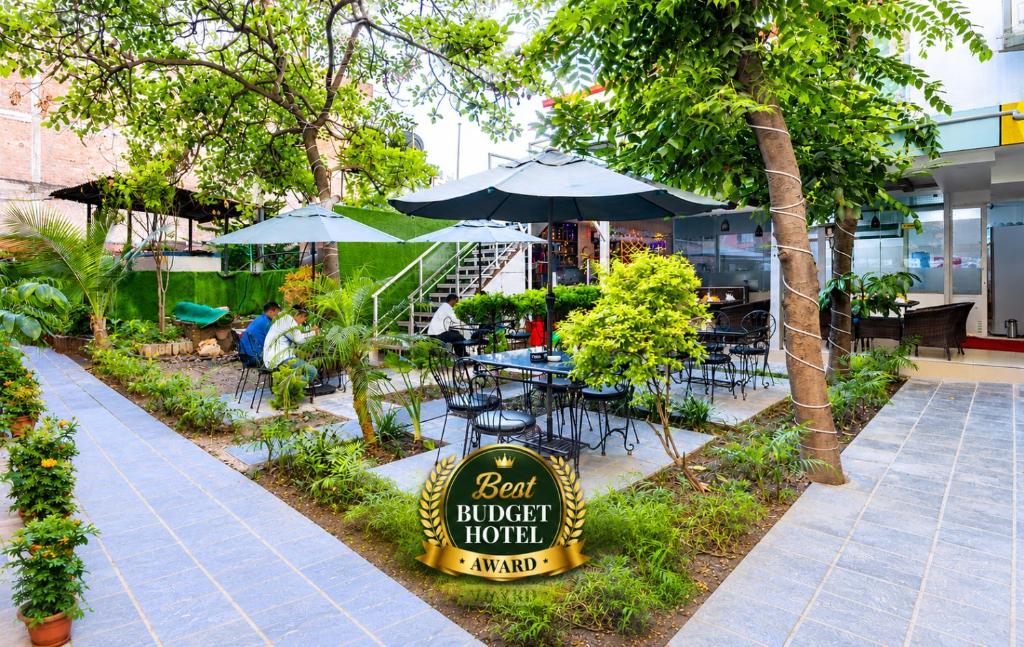a restaurant with tables and umbrellas in a courtyard at Hotel Sapana Garden Thamel in Kathmandu