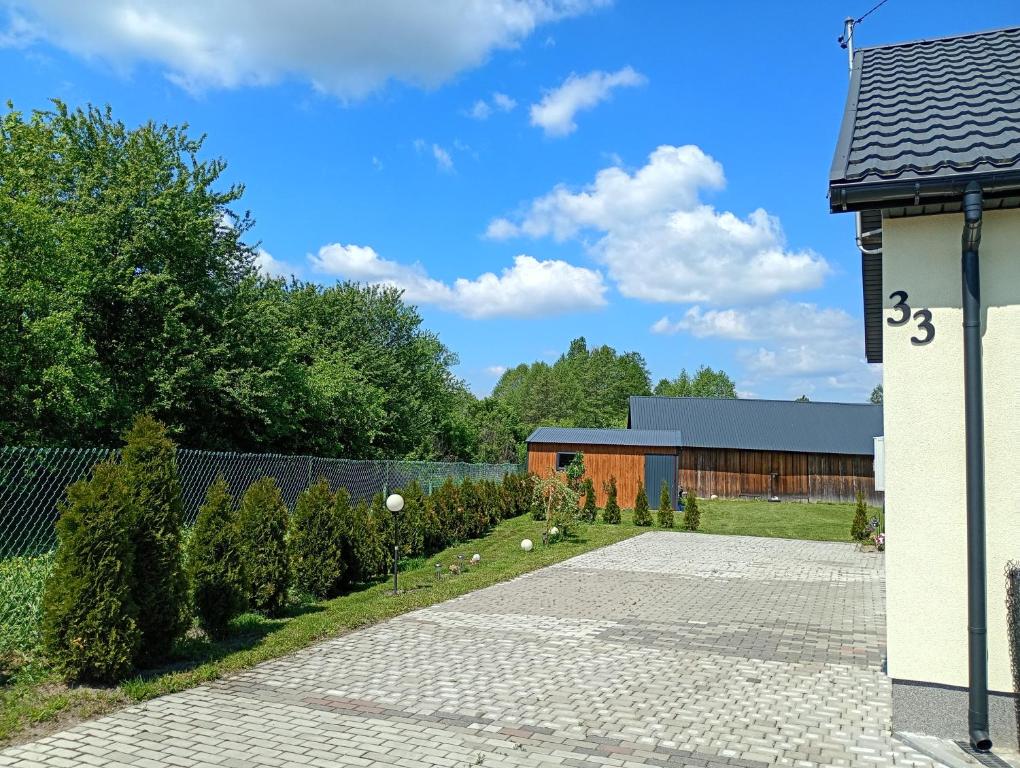 a driveway leading to a house with a garden at Noclegi u Franciszka in Trzebiesza
