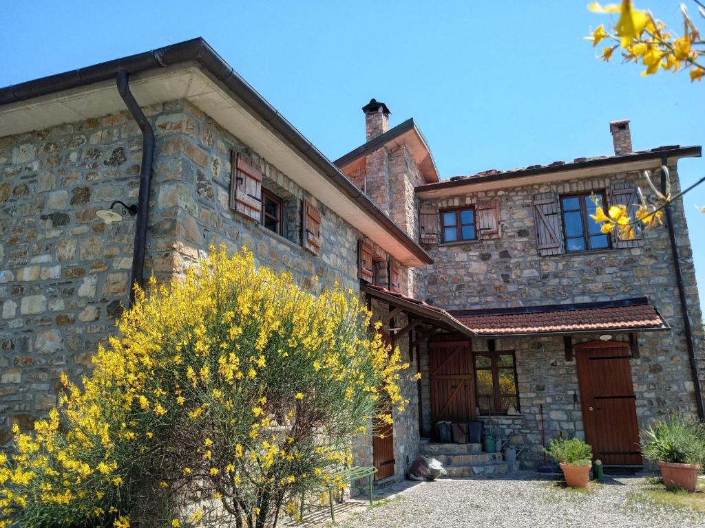 an old stone house with a tree in front of it at Casa della Barcareccia - per gruppi in Calice al Cornoviglio