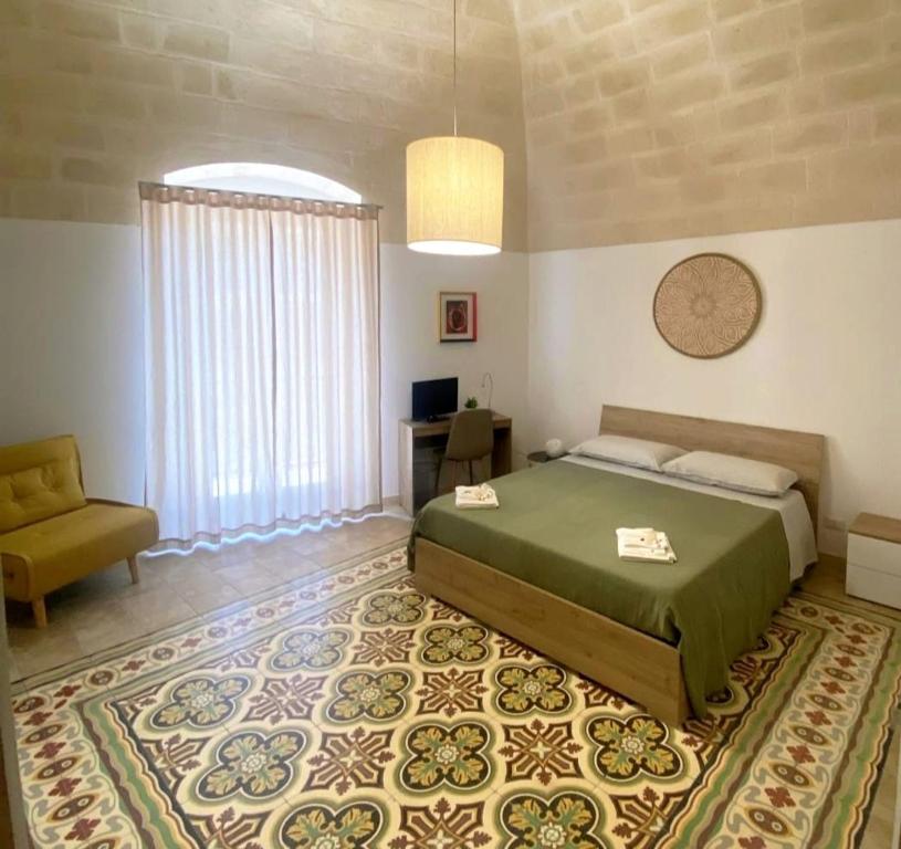 a bedroom with a bed and a chair and a table at Somnium Vitae - Casa Vacanze in Montescaglioso