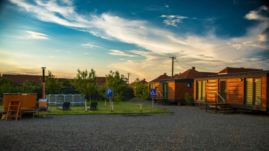 ein paar Holzhütten auf einem Parkplatz in der Unterkunft Tiny House Doi Frați in Drăguş