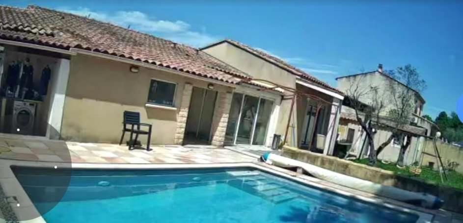 a swimming pool in front of a house at Maison 4 pièce , piscine in Avignon