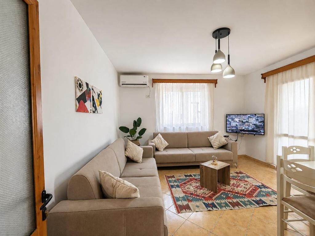 a living room with a couch and a tv at Vangert Apartment in Berat