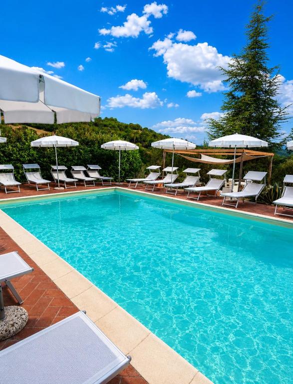 a large swimming pool with chairs and umbrellas at Il Borghetto di Pedana- in Città di Castello