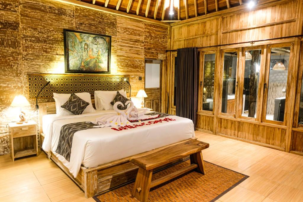 a bedroom with a large white bed in a room at Rise Simpangan Villa in Payangan