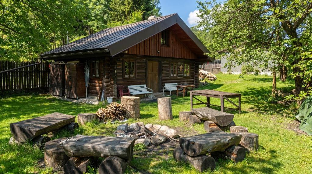 a log cabin with a fire pit in front of it at SRUB pod třešněmi - Cherry Trees Cabin in Vrchlabí