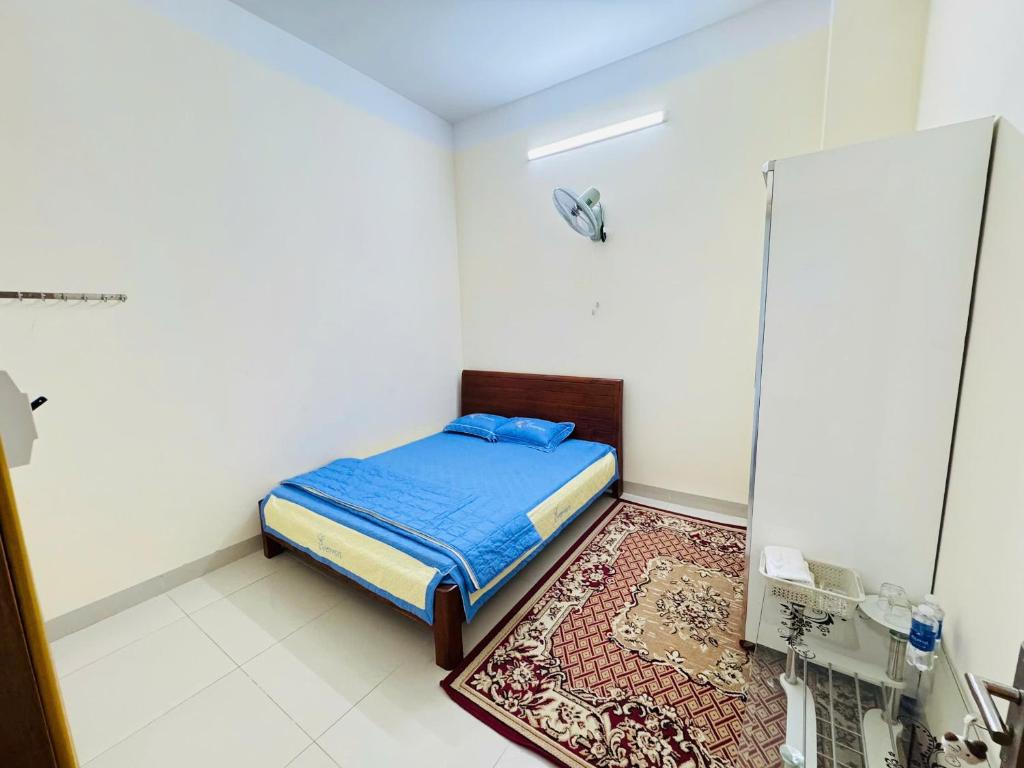 a small bedroom with a bed and a rug at Nhà nghỉ B48 in Cù Lao Tâu