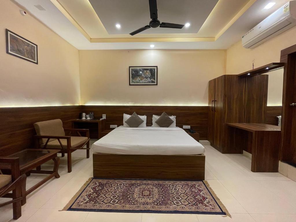 a hotel room with a bed and a table and chairs at House M Lodge in Sawāi Mādhopur