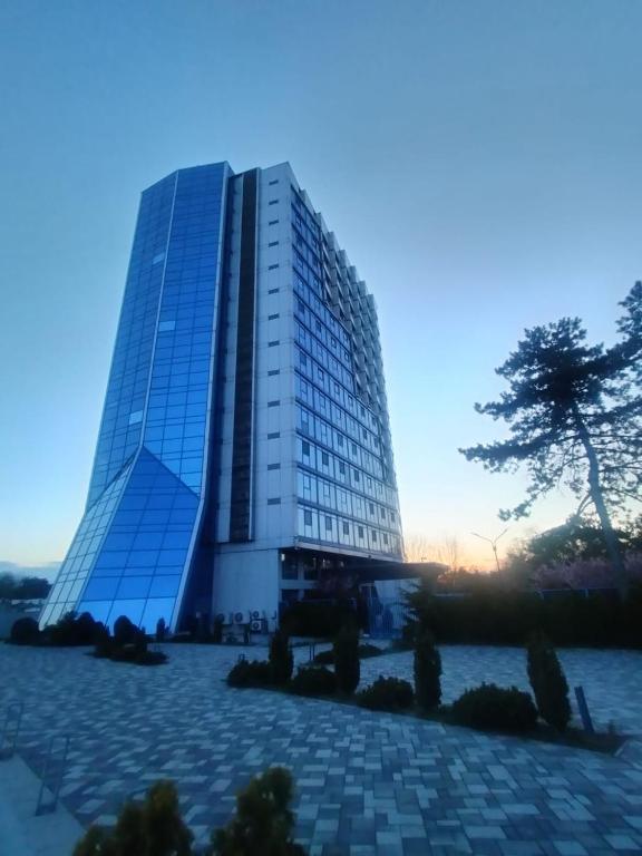 a tall building with a tree in front of it at Sea View Apartments Olimp by Stela in Olimp