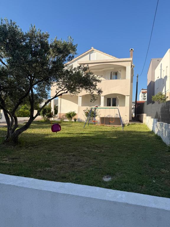 a red frisbee in the grass in front of a house at Apartment K&M in Bibinje