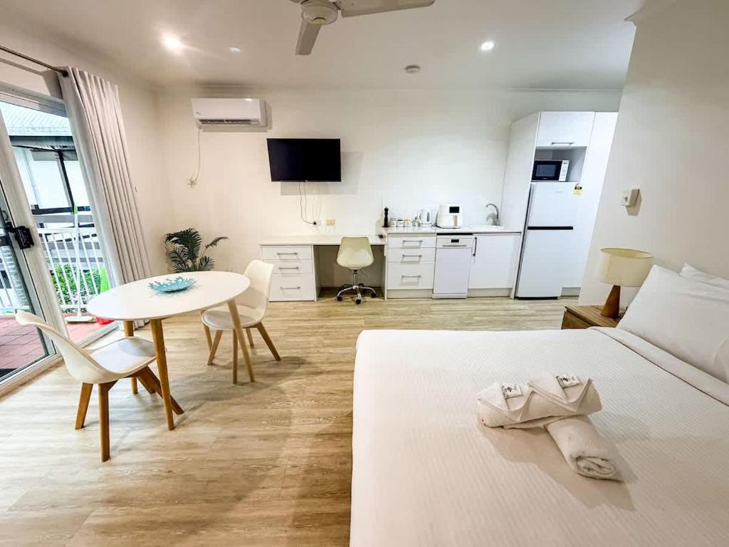 a bedroom with a bed and a table and a kitchen at U222 - The Serenity in Eimeo