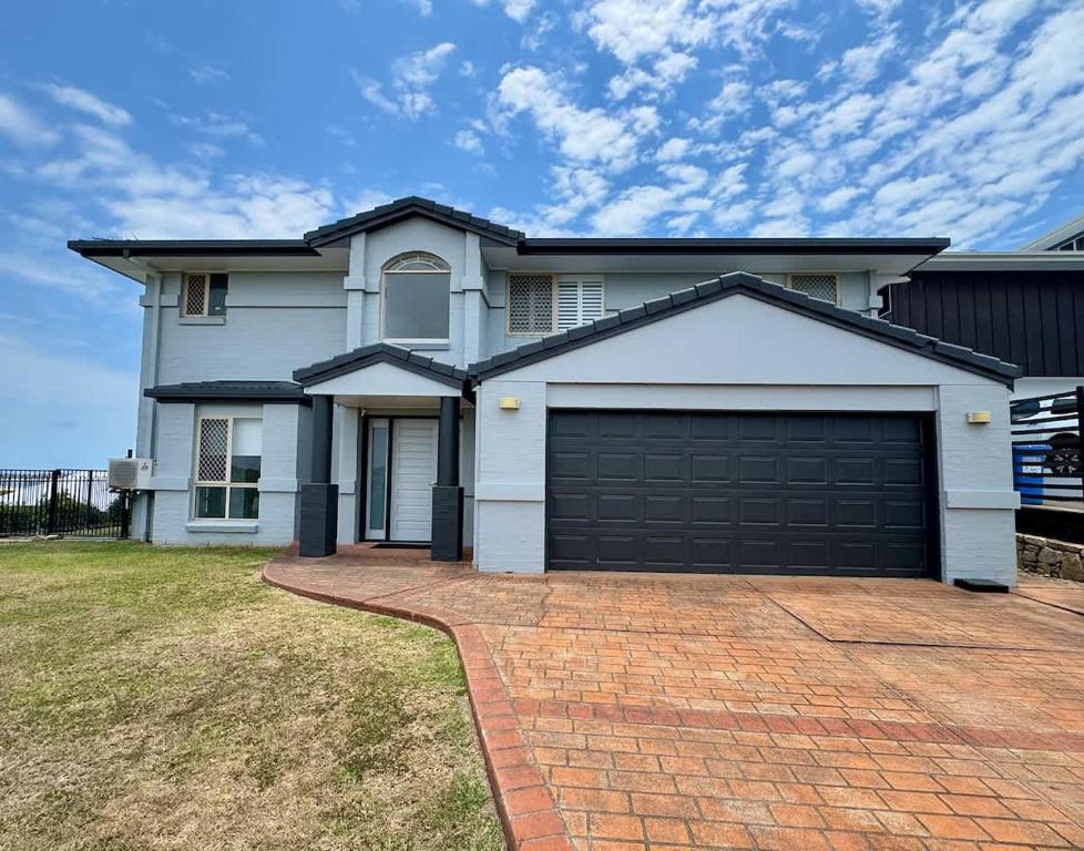 a large white house with a garage at Belle Vue - 4brm 2bth AC Pool Views in Eimeo