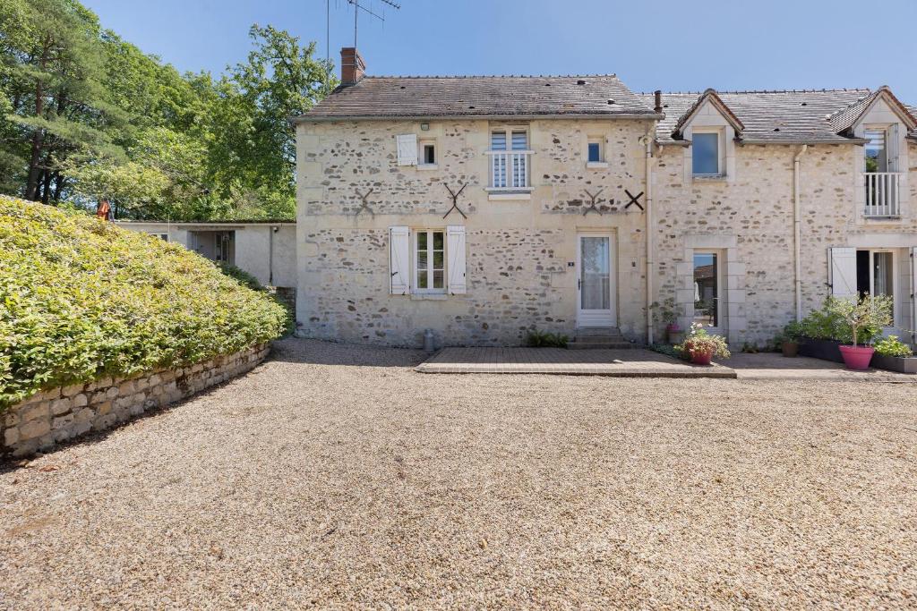 an old stone house with a gravel driveway at Le Vallon in Mondion