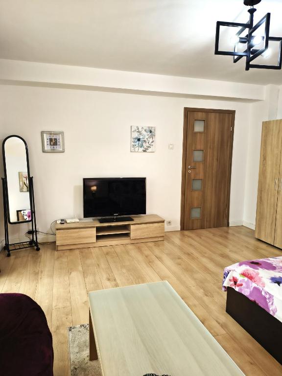 a living room with a flat screen tv on the wall at Gamma Group Sud in Bucharest