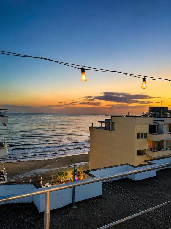 a view of the ocean at sunset from a building at Hersol Skyline in Durrës